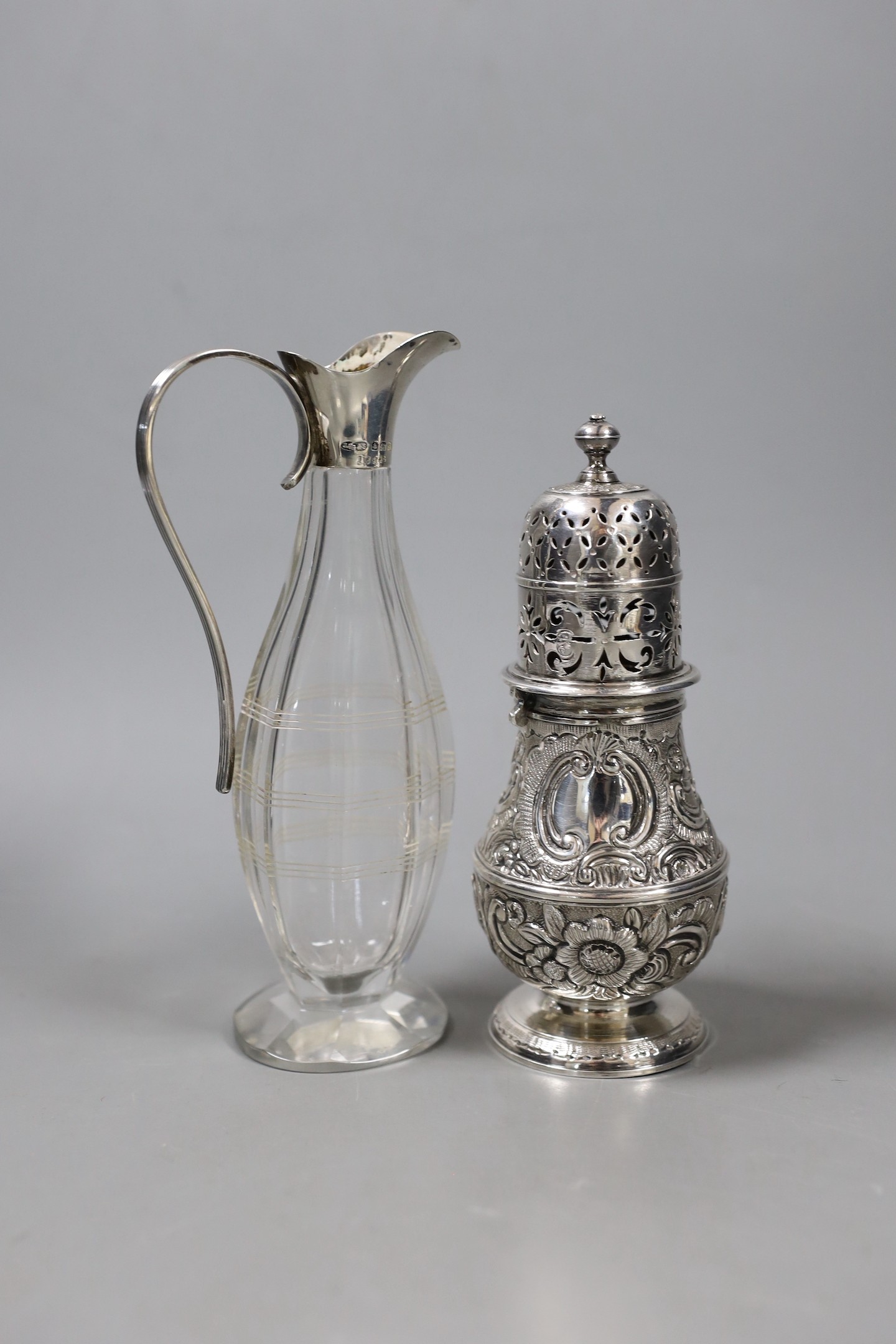 A continental white metal baluster caster (top and base associated), 14.2cm and a 1920's silver mounted condiment bottle.